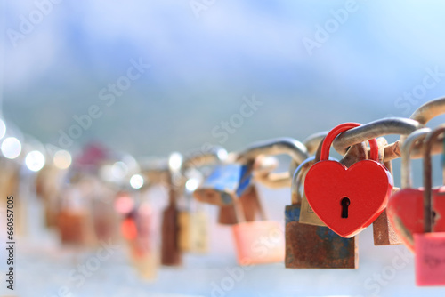 Love locks and hearts. Close-up of love lock with a red heart hanging on chain in on background of the sea. The key locks for lovers promise love. Concept image for valentine's day. Loyalty and love