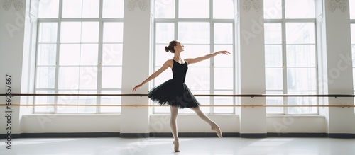 Beautiful ballet dancer in black costume is practicing at home