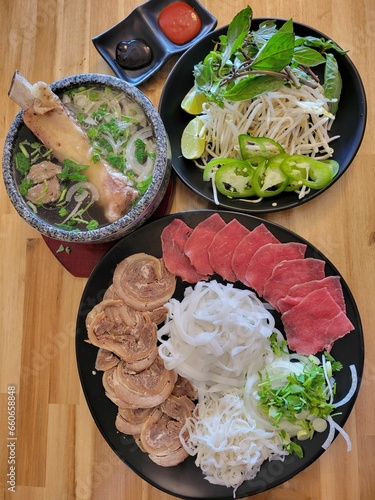 Pho in a stone bowl with steak on the side