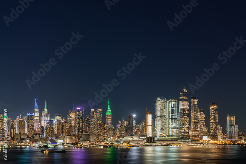 Aerial New York City skyline from New Jersey over the Hudson River with the skyscrapers of the Hudson Yards district at night. Manhattan  Midtown  NYC  USA. A vibrant business neighborhood