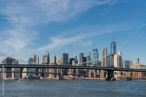 Brooklyn and Manhattan bridge with New York City financial downtown skyline panorama at day time over East River with blue cloudy sky. © VideoFlow