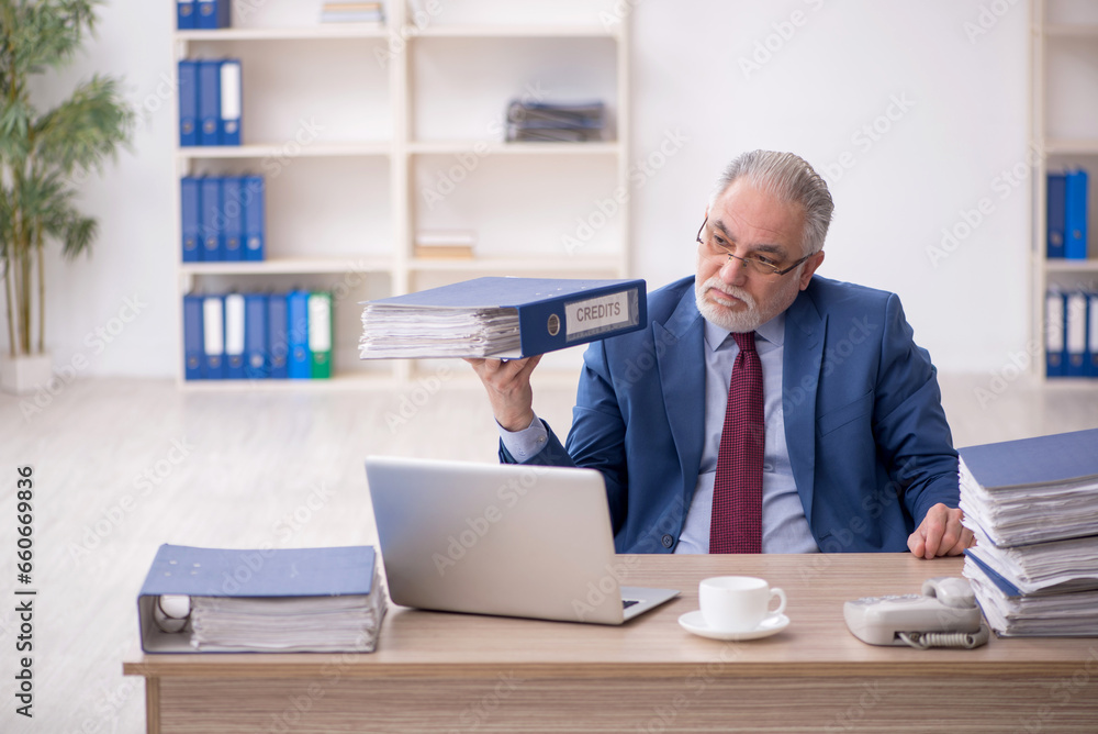 Old male employee and too much work at workplace Old male employee and too much work at workplace
