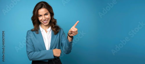 Cheerful businesswoman pointing to copy space on blue background. © Danny