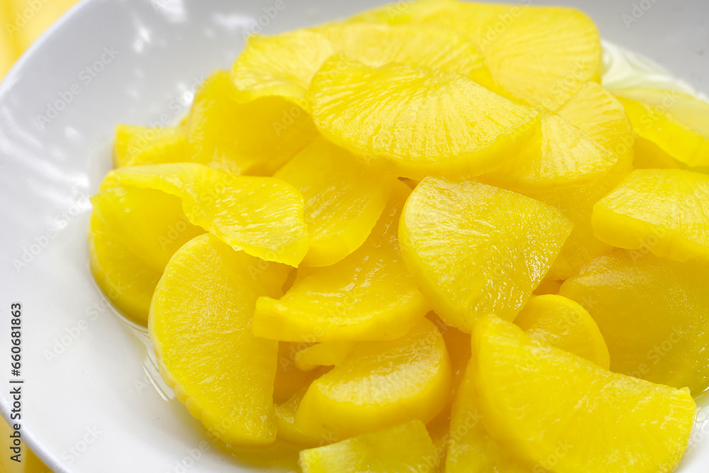 Sweet and tart slices of yellow pickled daikon, known as takuan in Japan and danmuji in Korea. Sweet and tart slices of yellow pickled daikon, known as takuan in Japan and danmuji in Korea.