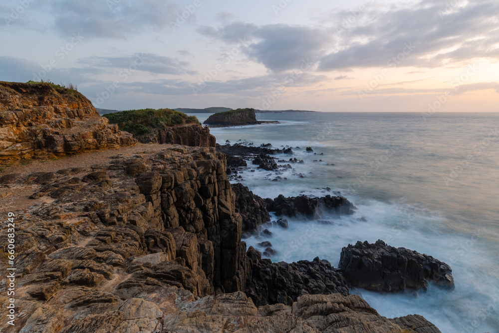 Rock cliff view at Minammurra lookout with cloudy sky, Australia.