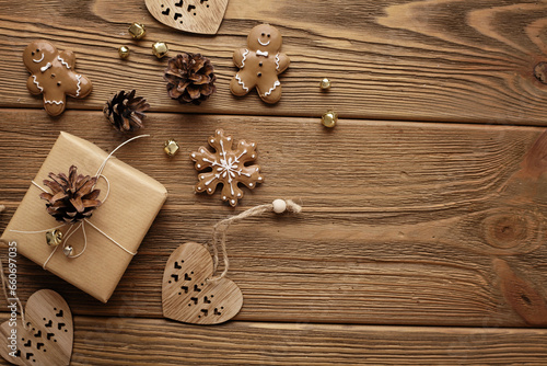 Christmas decoration with gift boxes, pine cones and gingerbread cookie ornaments on rustic wooden background