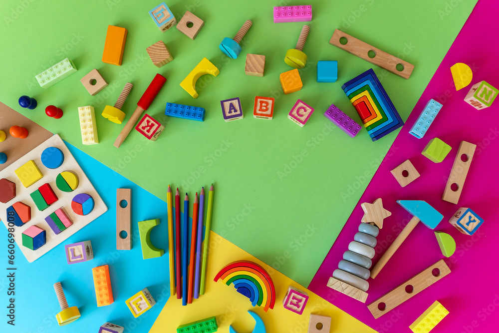 Wooden kids toys on colourful paper. Educational toys blocks, pencils. Toys for kindergarten, preschool or daycare. Back to school. Copy space for text. Wooden kids toys on colourful paper. Educational toys blocks, pencils. Toys for kindergarten, preschool or daycare. Back to school. Copy space for text.