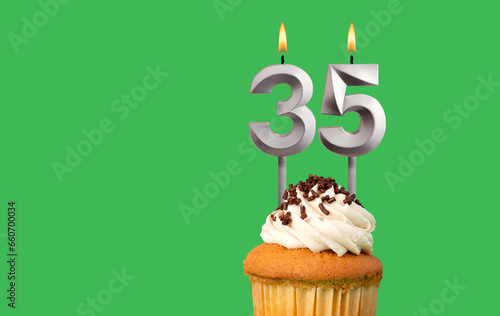Birthday with number 35 candle and cupcake - Anniversary card on green color background