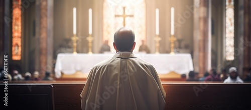 Rear view of a priest praying in church photo