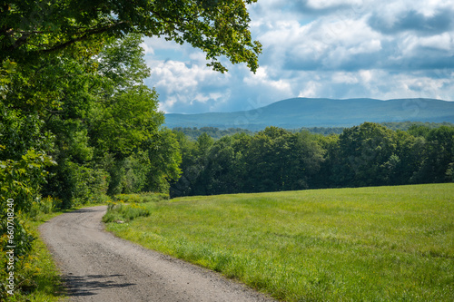 Rural landscape with dirt road, forest and mountain, Greensboro, Vermont, New England, United States. Photo taken in August 2023.