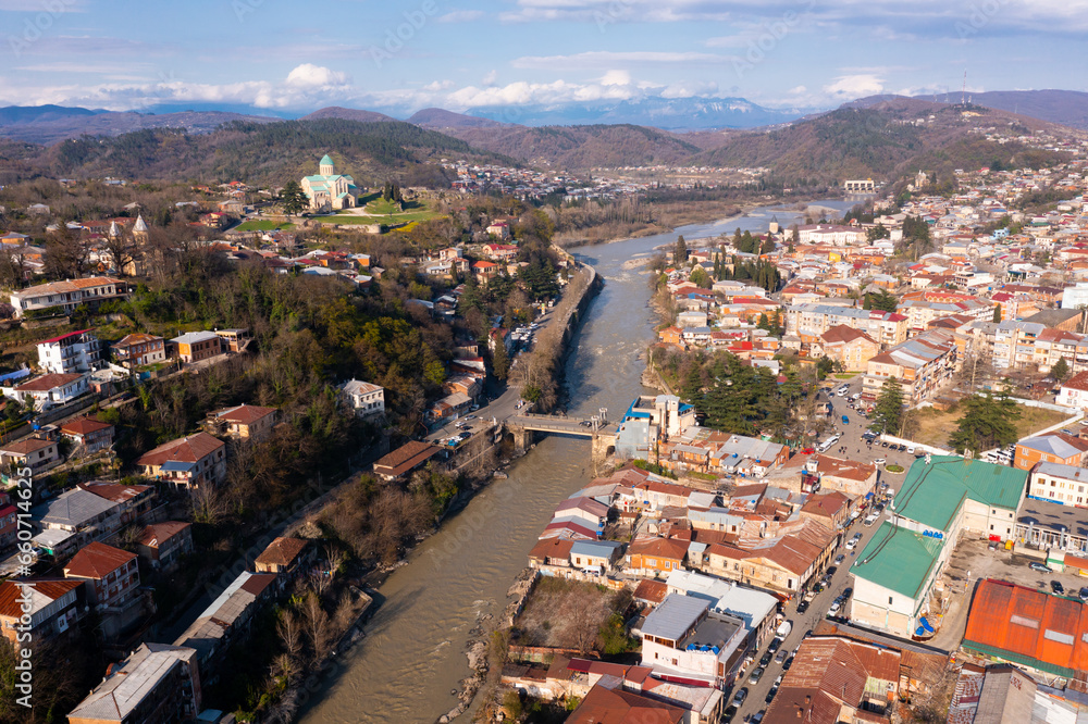 View from drone of houses of georgian Kutaisi city on banks of Rioni river in spring day