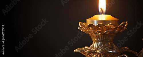 Closeup of a quietly flickering candle, set on a ornate candlestick, symbolizing the light of hope and faith that burns within the hearts of worshippers.