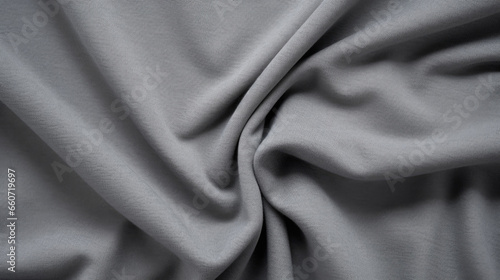 Texture of a knitted cotton jersey fabric, with a stretchy and smooth texture and a heather grey color. The fabric is comfortable and easy to work with, making it a popular choice for tshirts