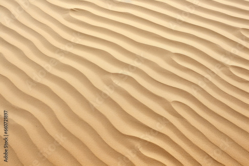 Texture of rippled sand on a peaceful beach, with gentle ridges and valleys formed by the constant motion of the waves. © Justlight