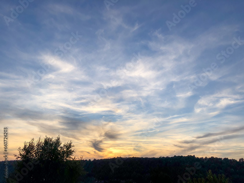 illustration d un coucher de soleil avec un ciel bleu fonc   tr  s nuageux 