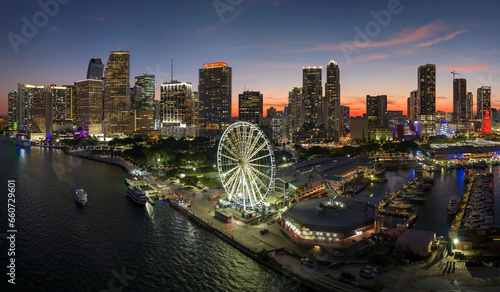 High illuminated skyscrapers of Brickell, city's financial center. Skyviews Miami Observation Wheel at Bayside Marketplace with reflections in Biscayne Bay water and US urban landscape at night