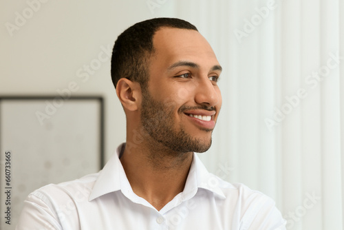 Portrait of handsome young man in white shirt indoors