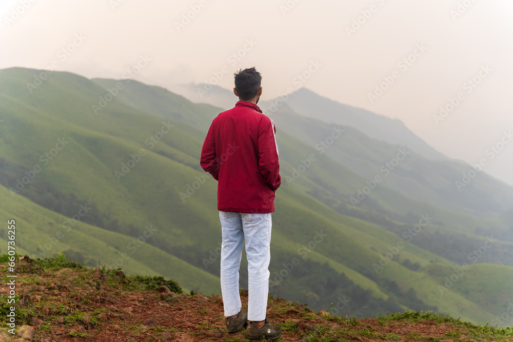 happy Young unknown man standing in front of mountain landscape happy Young unknown man standing in front of mountain landscape