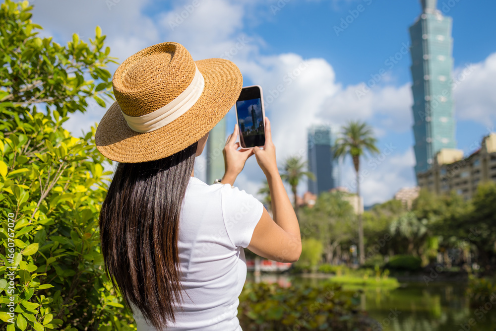 Woman visit Taipei city and use cellphone to take photo