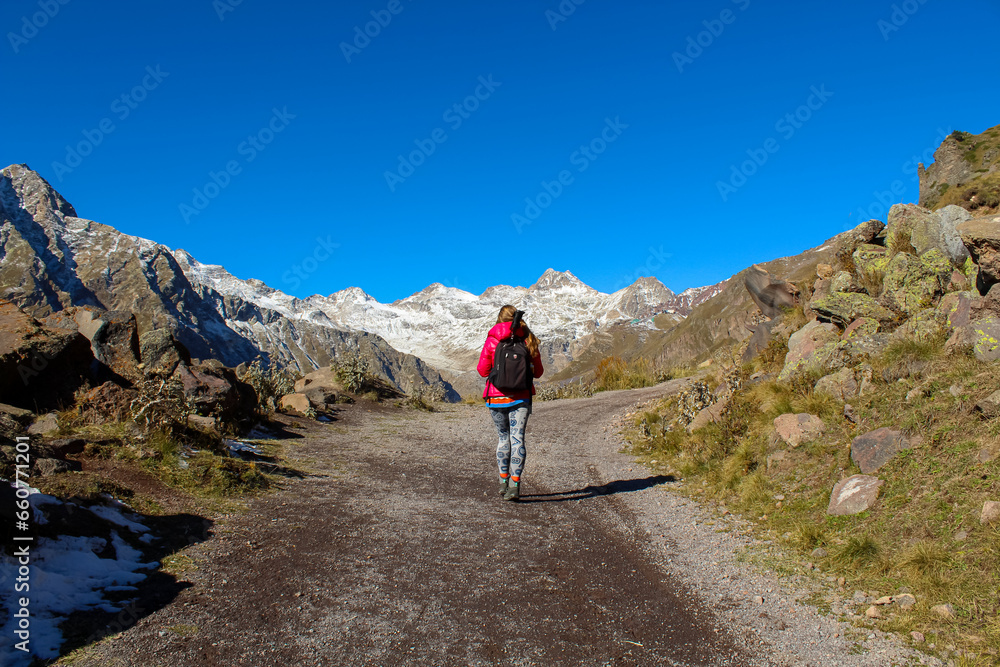 A girl on the trail looking at the mountains at the distance behind the hills
