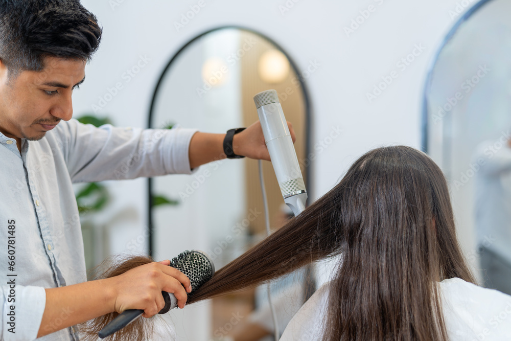 Men drying and straightening the long hair of a woman Men drying and straightening the long hair of a woman