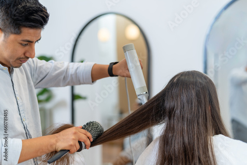 Men drying and straightening the long hair of a woman