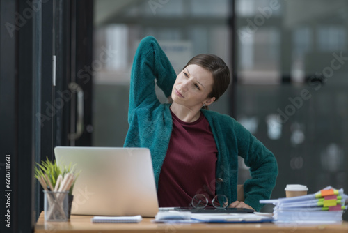 Office syndrome concept. Beautiful businesswoman feeling neck pain after working on a computer laptop for a long time.