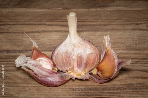 Garlic Bulb Segmented On Wood Grain Background