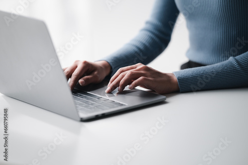 Businesswoman hands using laptop computer placed on desktop.
