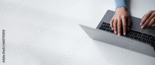 Businesswoman hands using laptop computer placed on desktop.