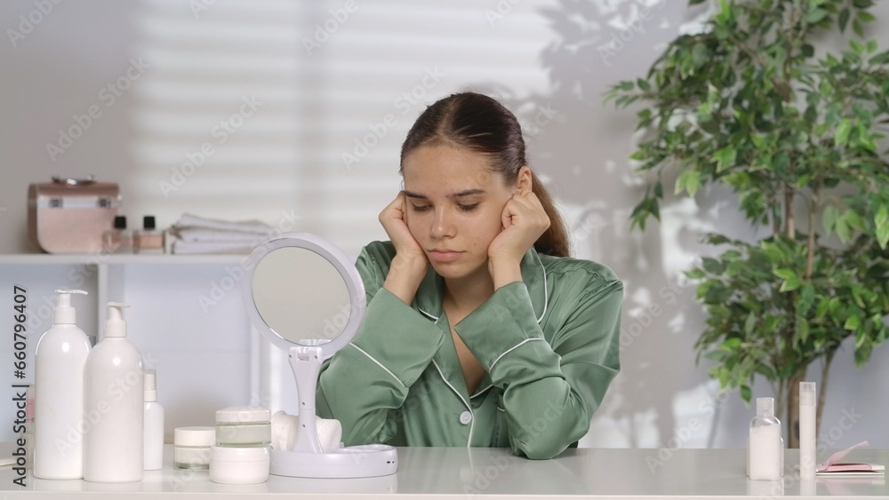 Portrait of a frustrated woman at her dressing table in front of a mirror. The disappointed woman is suffering because of her problem skin. Portrait of a frustrated woman at her dressing table in front of a mirror. The disappointed woman is suffering because of her problem skin.