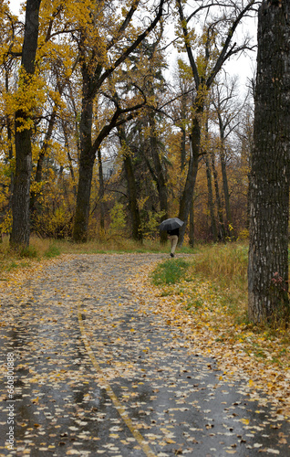man with umbrella walking in the autumn park