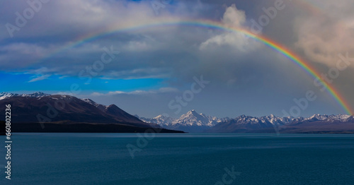 Rainbow scene with mountain view of alpine as snow-capped mount peaks and blue lake in Winter mountains, panorama scene