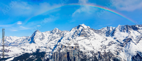 The mountain view of rainbow scene with alpine as snow-capped mount peaks in Winter mountains