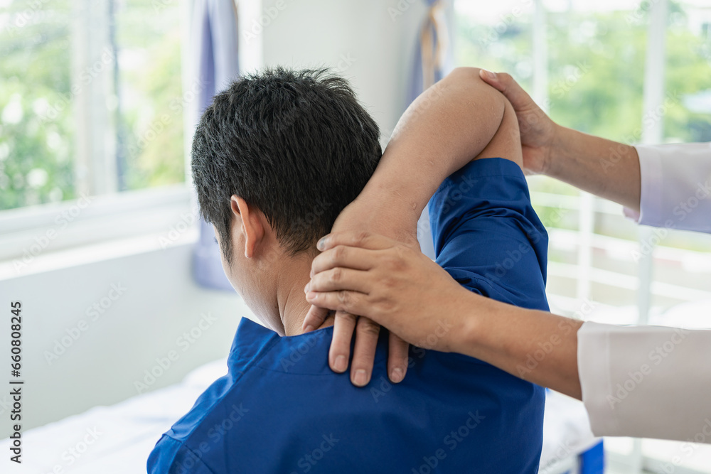 Obraz premium Physical therapist working on the treatment of the injured arm of an Asian male athlete patient. Stretch and exercise Perform pain rehabilitation therapy in the medical clinic.