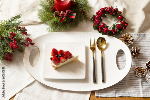 Piece of cake on plate and Christmas decorations on table