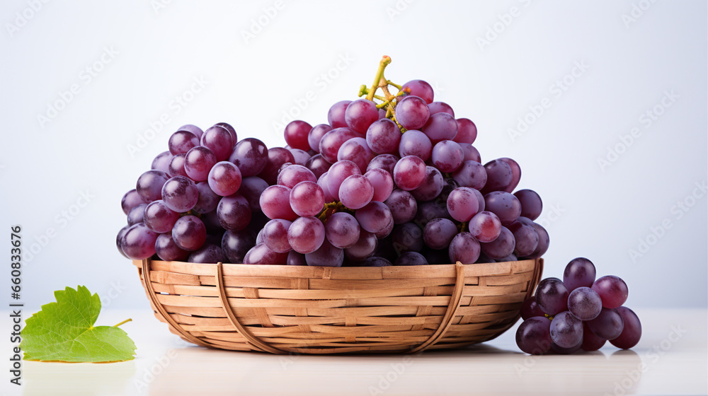 A bunch of purple grapes placed on a basket woven from bamboo on white background. A bunch of purple grapes placed on a basket woven from bamboo on white background.