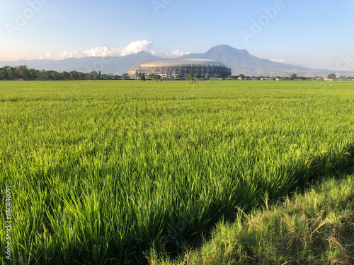 The beauty of the Gelora Bandung Lautan Api Stadium with a view of rice fields and mountains in Bandung photo