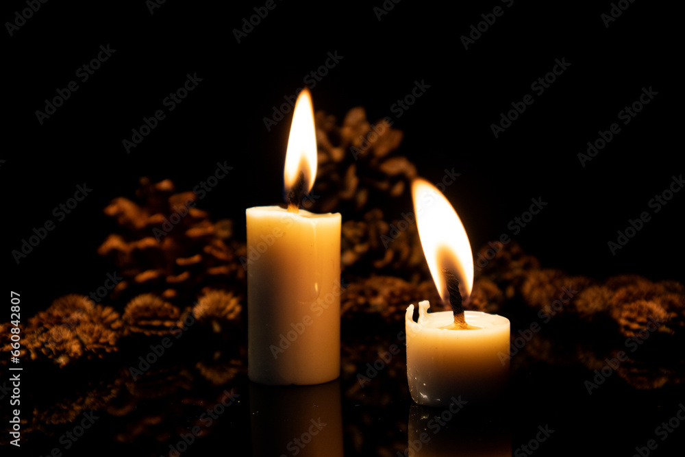 Two candles with pine wood flowers Two candles with pine wood flowers