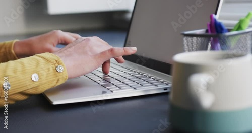 Wallpaper Mural Midsection of biracial woman sitting at desk using laptop with copy space at home, slow motion Torontodigital.ca