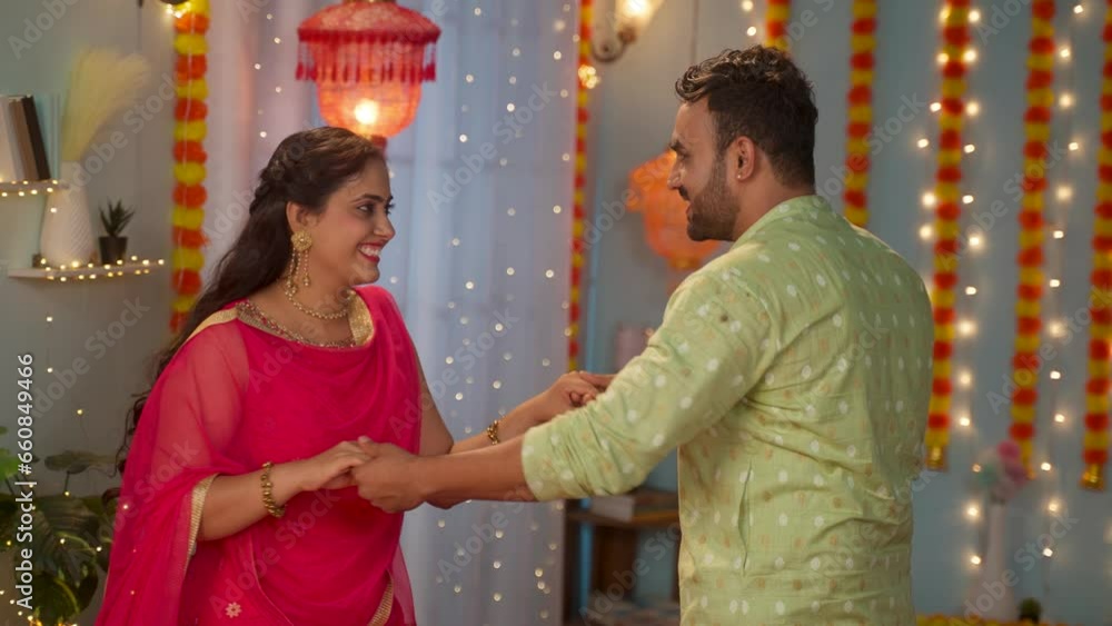 Happy young couple dancing together during diwali festival holiday celebration at home - concept of relationship enjoyment, entertainment and traditional attire or wear Happy young couple dancing together during diwali festival holiday celebration at home - concept of relationship enjoyment, entertainment and traditional attire or wear