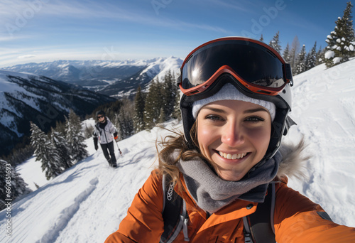 Selfie of a young 22s year old northern European woman with ski goggles in ski clothing and helmet skiing content and happy on top of snowy mountain 