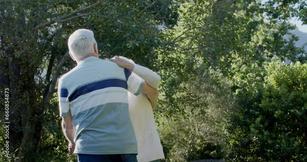 Happy senior caucasian couple dancing in sunny garden, slow motion
