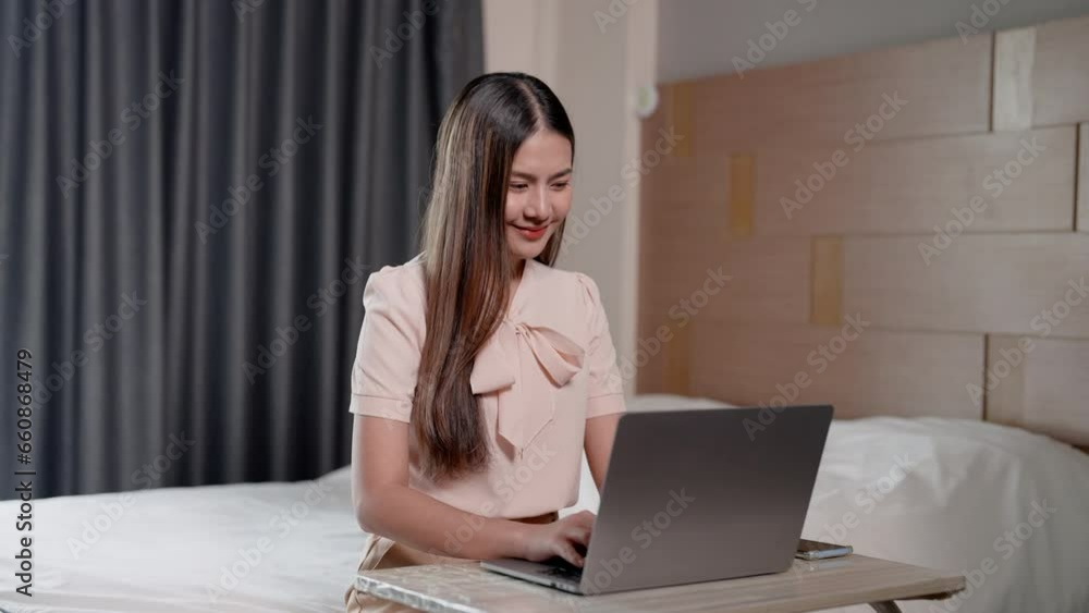 Beautiful Asian woman with long hair Wear complete work clothes for online meeting with supervisor. Discussing urgent work via laptop computer Staying in bed in bedroom at home during the holidays Beautiful Asian woman with long hair Wear complete work clothes for online meeting with supervisor. Discussing urgent work via laptop computer Staying in bed in bedroom at home during the holidays