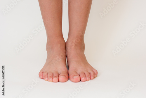 Fototapeta Naklejka Na Ścianę i Meble -  Cropped barefoot child legs on white background. 