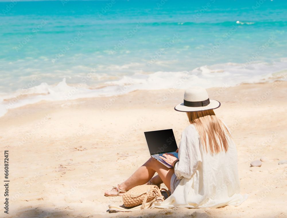 young woman uses laptop computer on the beach. distance work, freelancer and blogger concept. WiFi unlimited