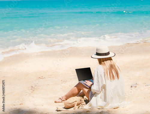 Obraz na płótnie young woman uses laptop computer on the beach. distance work, freelancer and blogger concept. WiFi unlimited w salonie