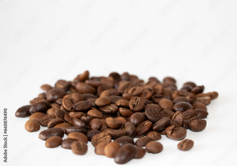 Coffee beans scattered. Aromatic brown coffee beans scattered on surface isolated on white background. Selective Focus. Coffee beans scattered. Aromatic brown coffee beans scattered on surface isolated on white background. Selective Focus.