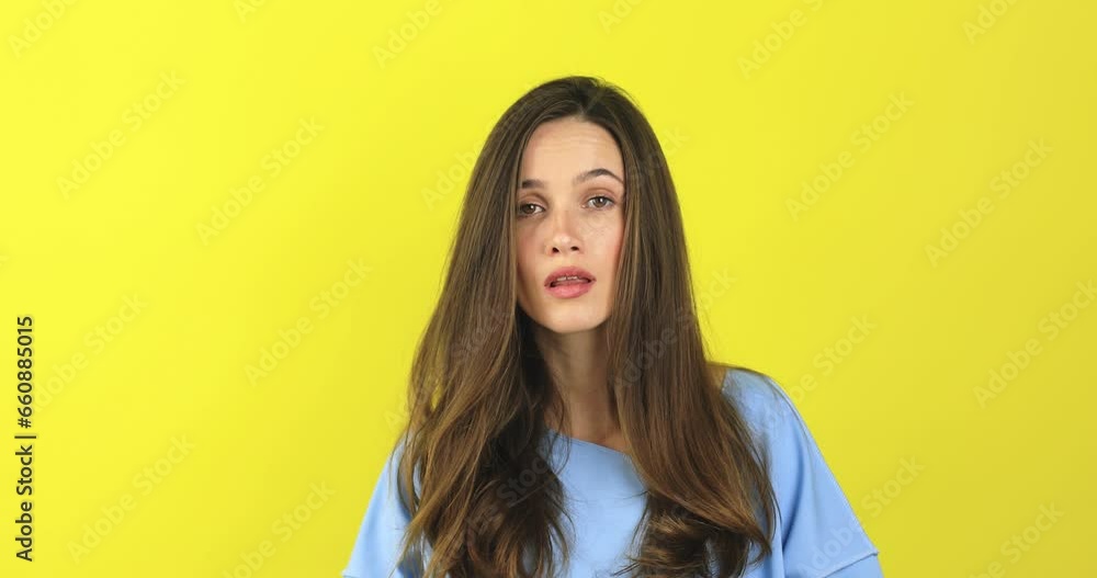 Brunette curly woman threatens with a fist is isolated on yellow background, shows fist has annoyed face expression going to revenge or threaten someone makes serious look. I will show you who is boss Brunette curly woman threatens with a fist is isolated on yellow background, shows fist has annoyed face expression going to revenge or threaten someone makes serious look. I will show you who is boss
