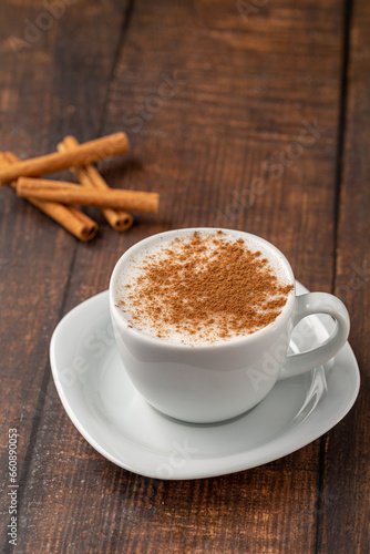 Cinnamon sprinkled salep in a white cup on wooden table